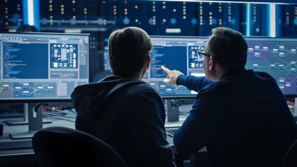 2 cybersecurity professionals pointing at a screen